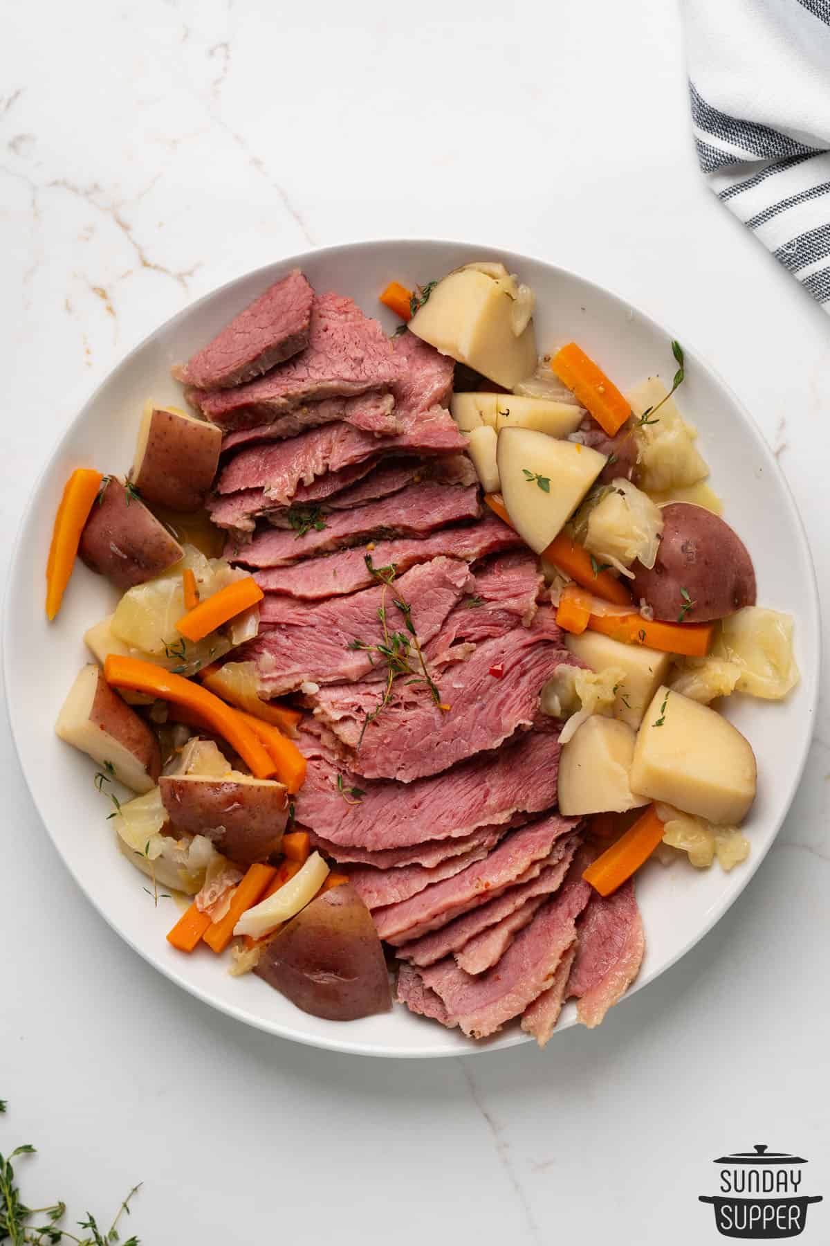 sliced corned beef on a serving dish with boiled vegetables