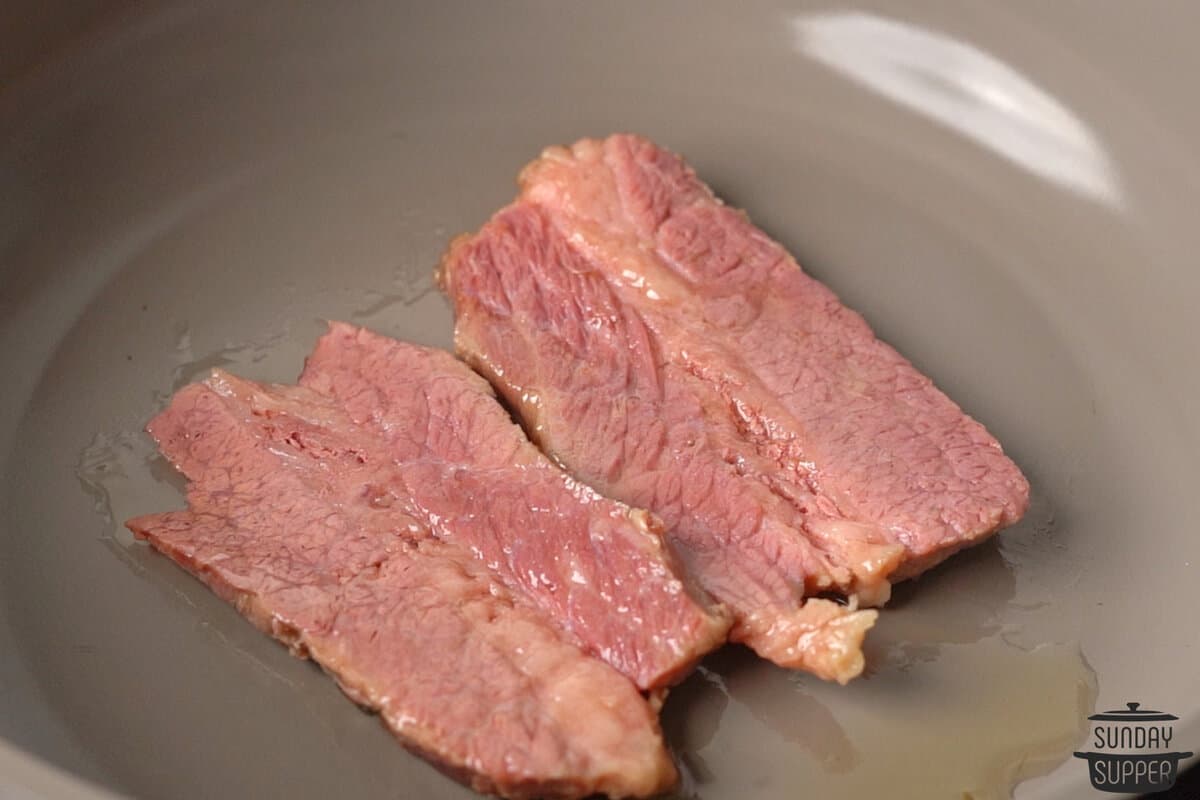 the corned beef in a pan with oil