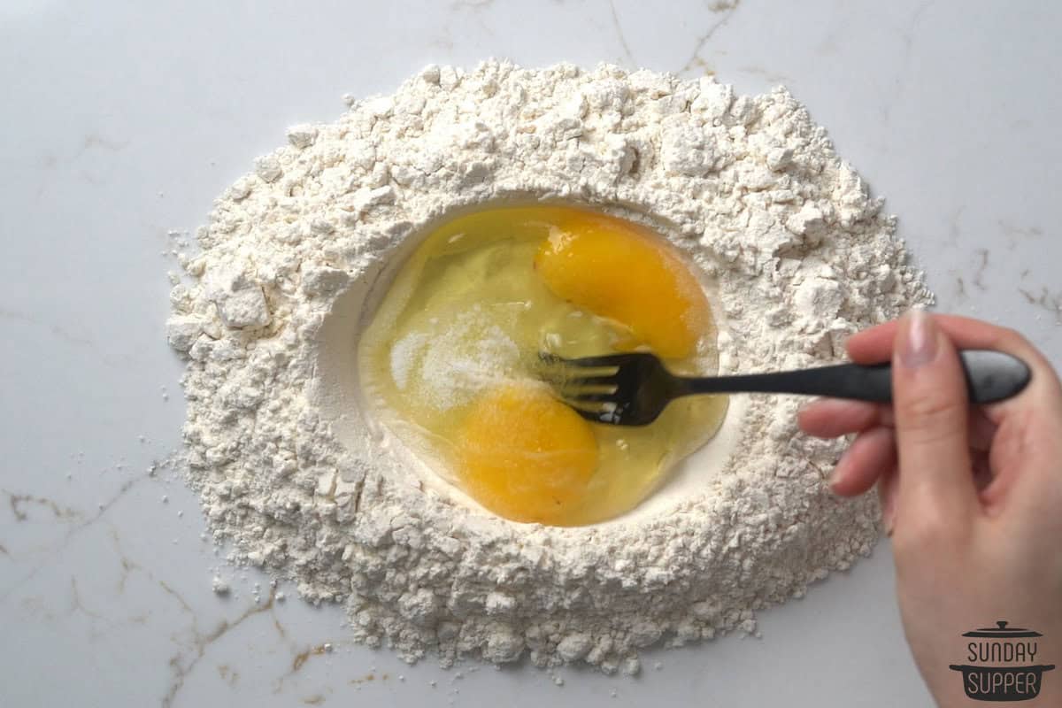 the eggs being carefully beaten with a fork
