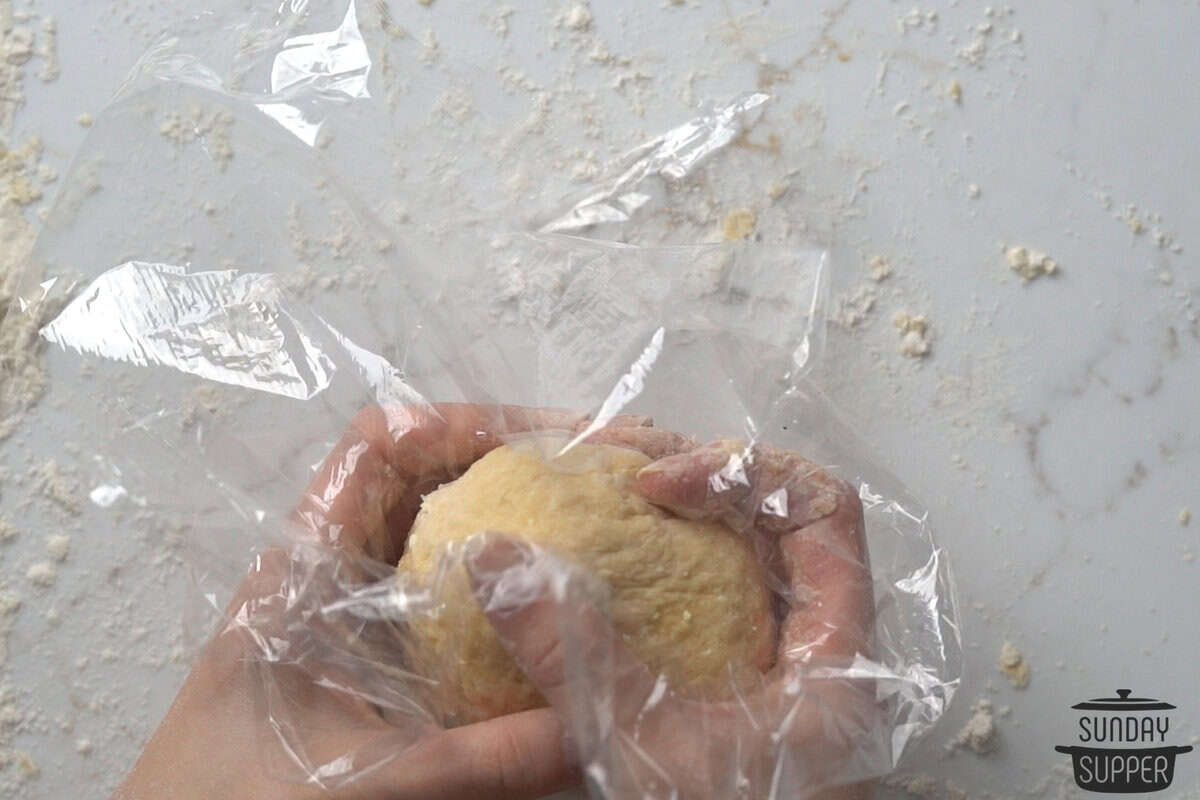 the dough ball wrapped in plastic wrap to rest