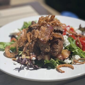 a plate of steak salad with goat cheese