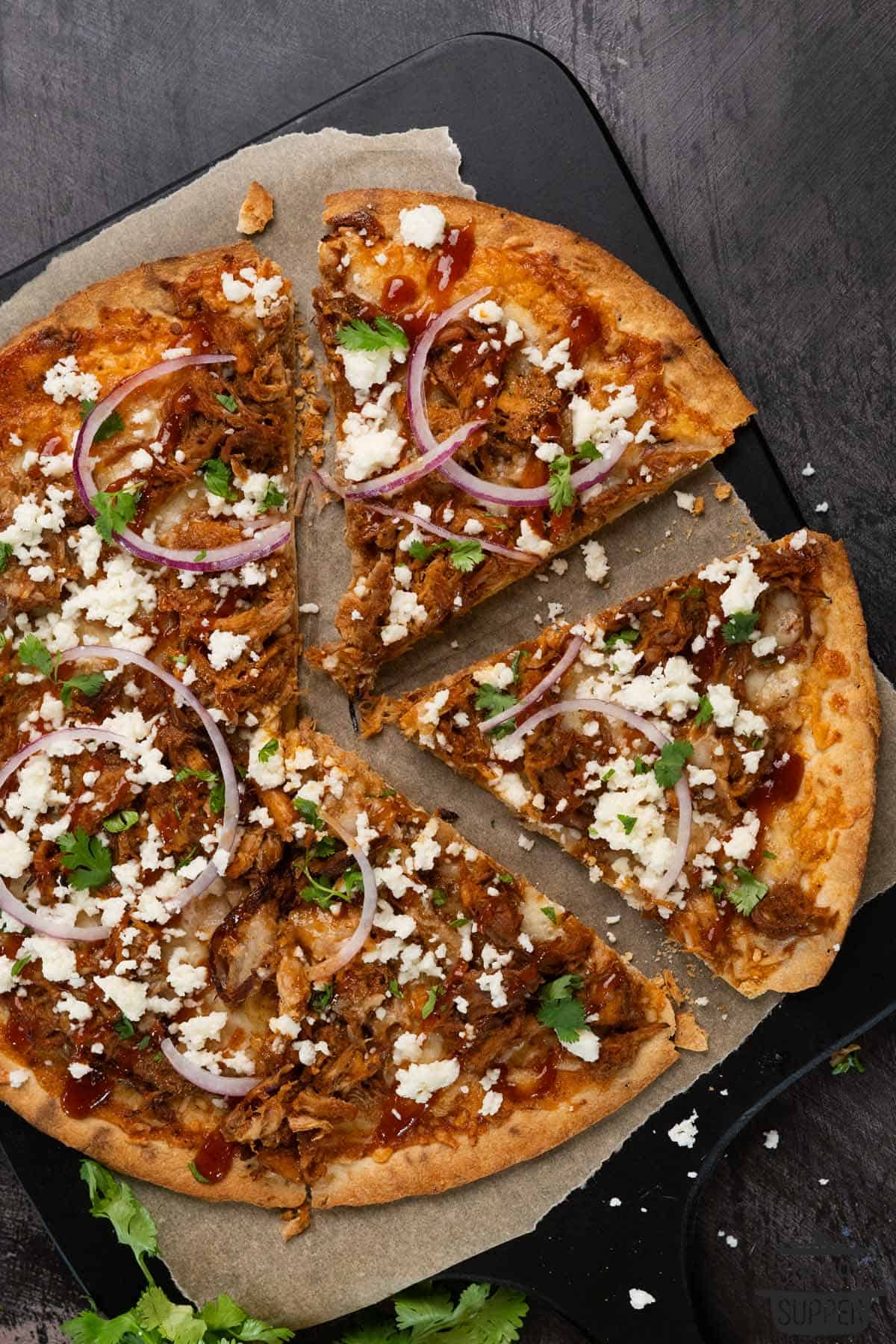 pulled pork pizza with two slices cut