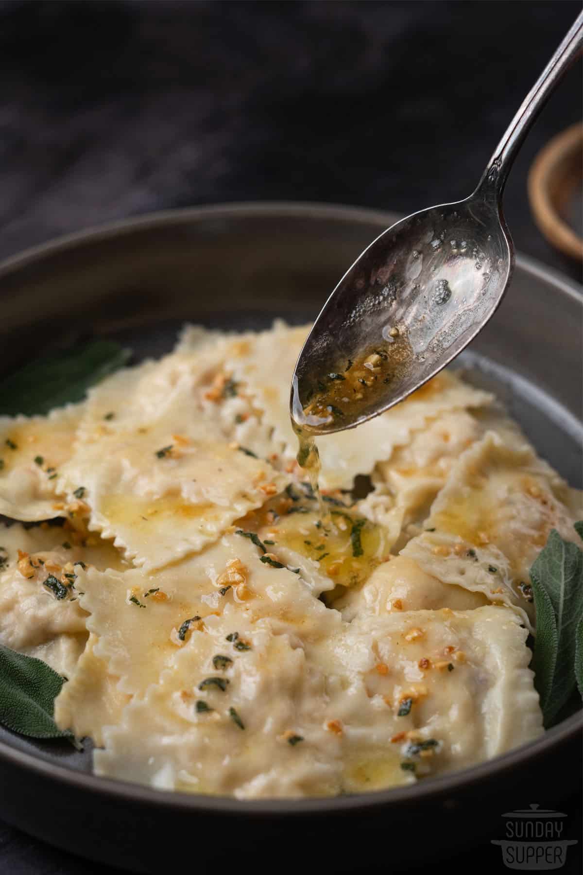 drizzling sage butter sauce over pasta