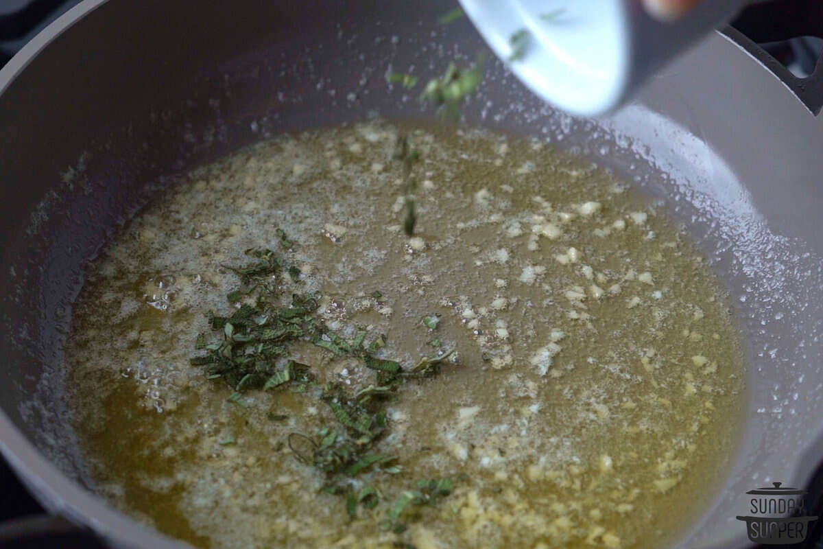 adding sage to butter sauce in pan