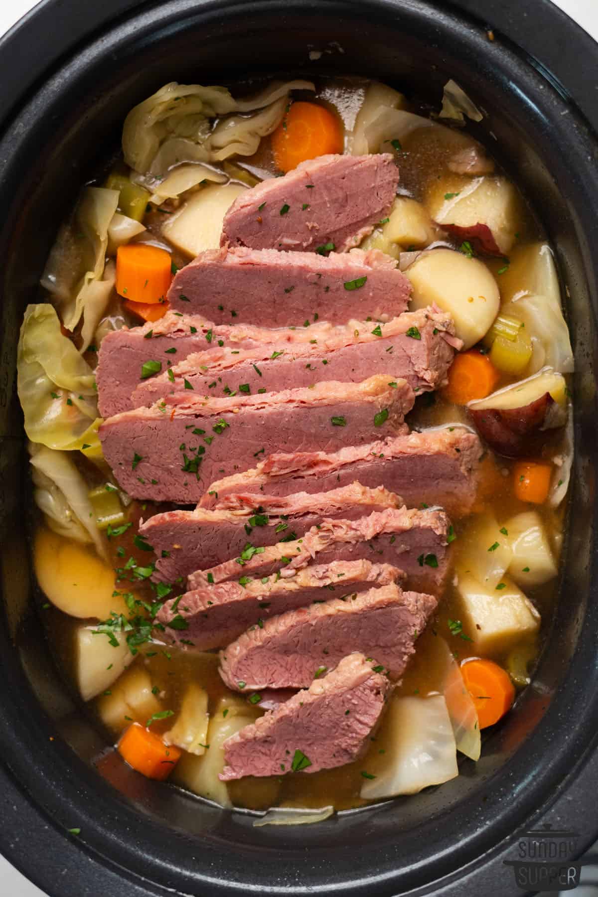 sliced corned beef in a pot with vegetables