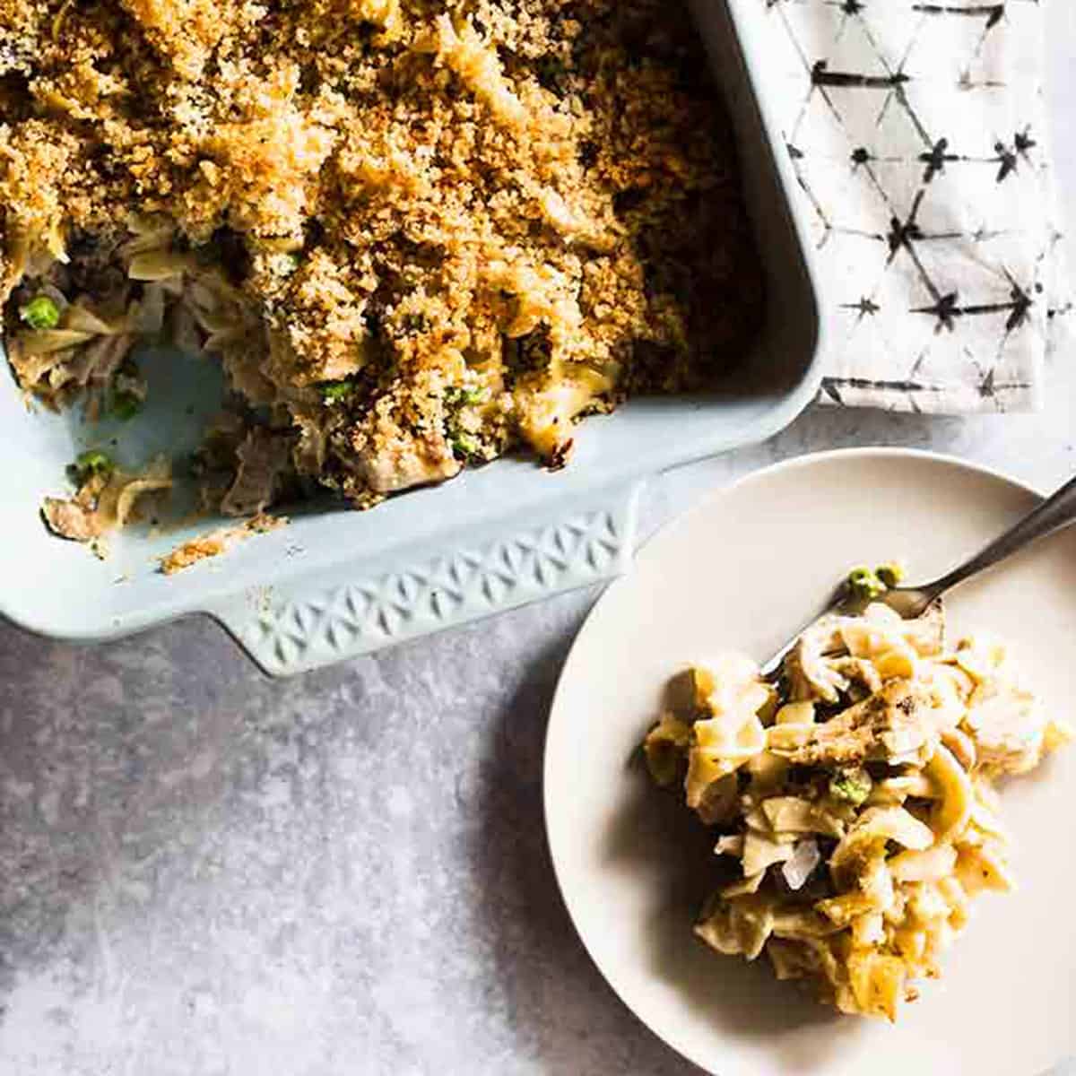 a casserole dish of turkey tetrazzini with a plate of tetrazzini