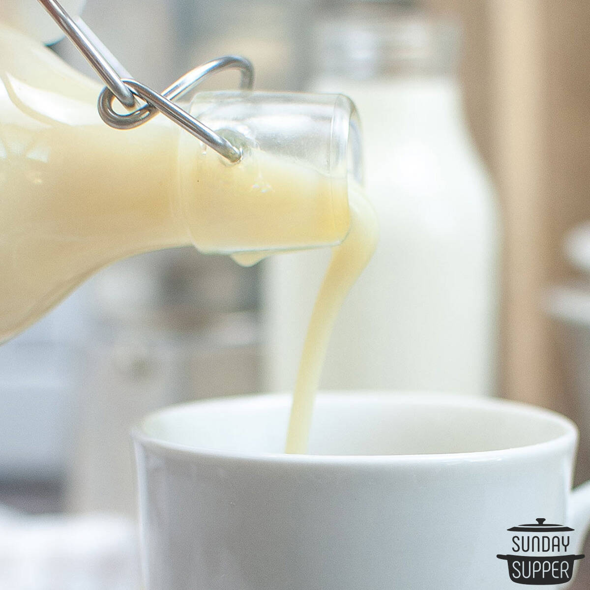 white chocolate syrup being poured into a mug