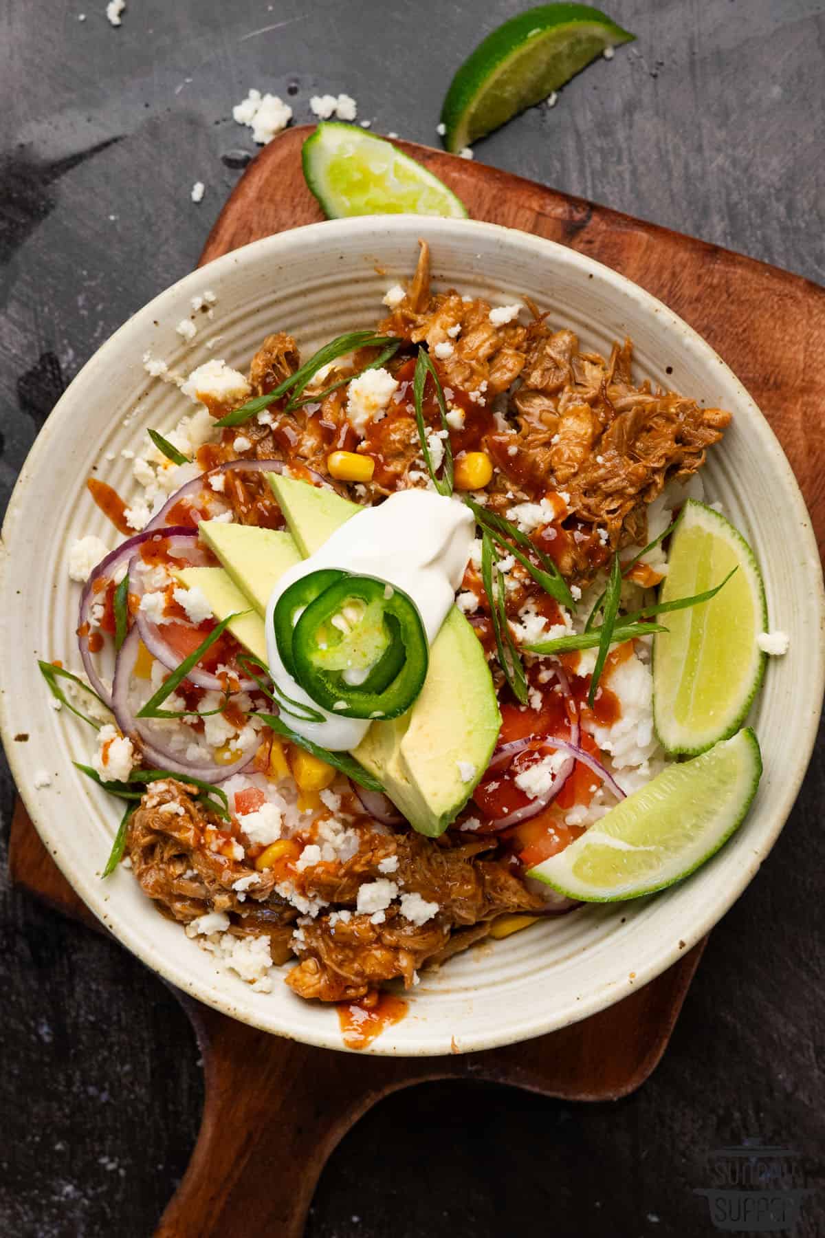pulled pork rice bowl on top of a cutting board
