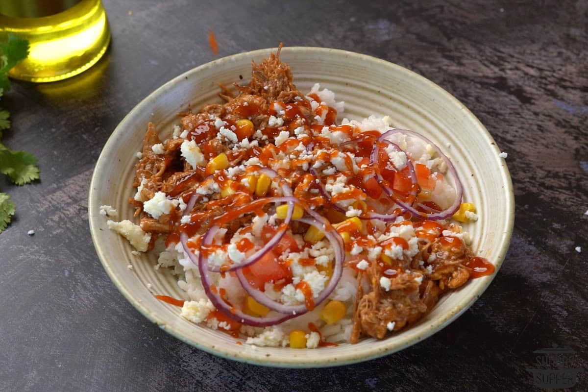 topping pulled pork rice bowl with sauce and cheese