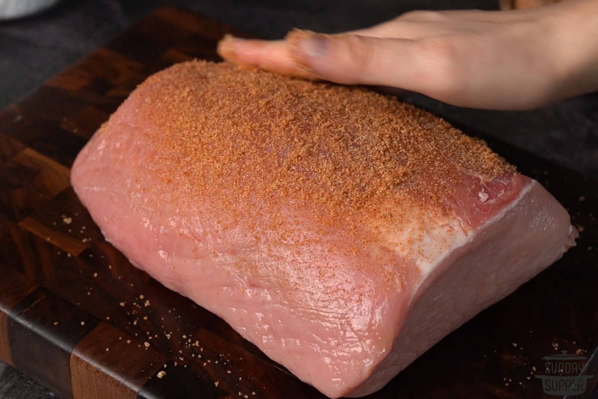 pulled pork seasonings being rubbed into a pork loin