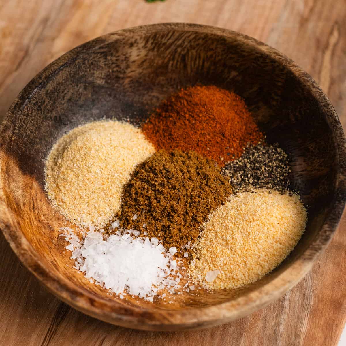 separate piles of seasonings in a wooden bowl