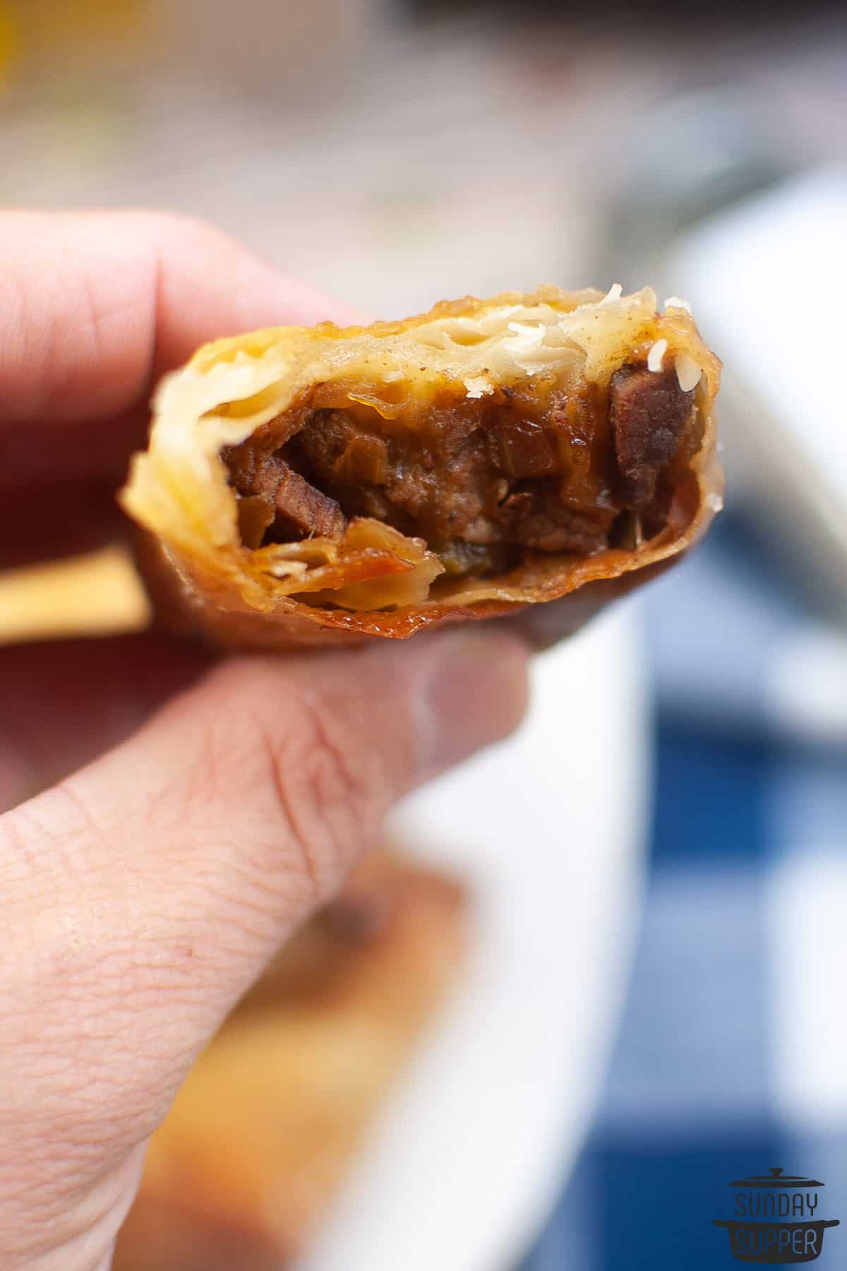 a cut open egg roll being held up