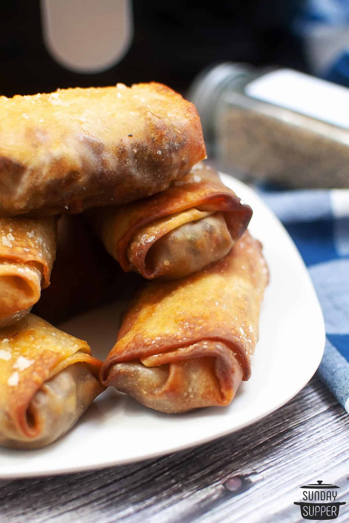 a plate of philly cheesesteak egg rolls