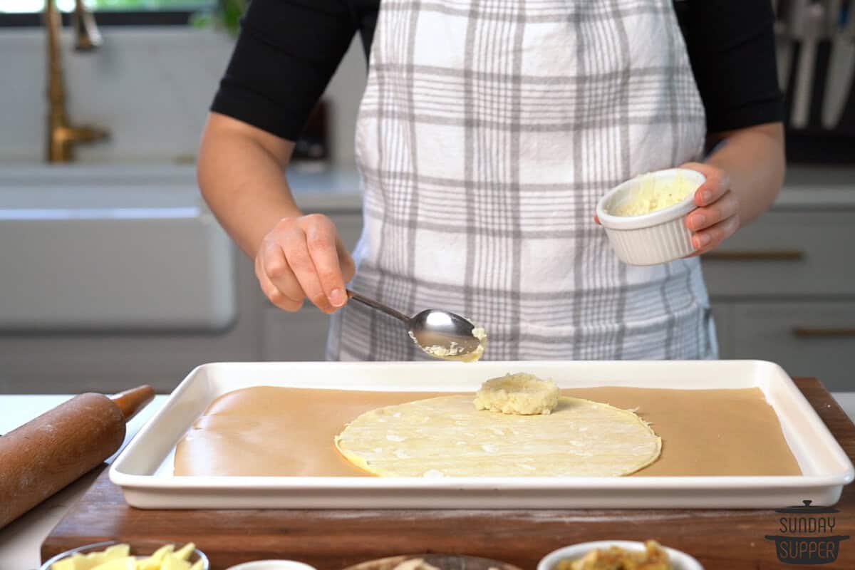 the potatoes being spread on the crust