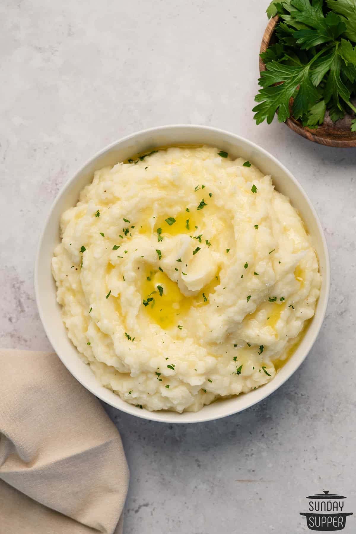 creamy mashed potatoes in a white bowl with melted butter