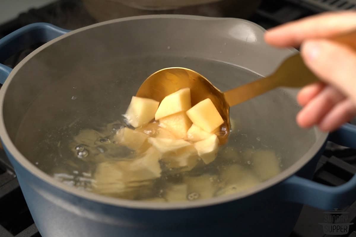 adding potato chunks to a pot of water