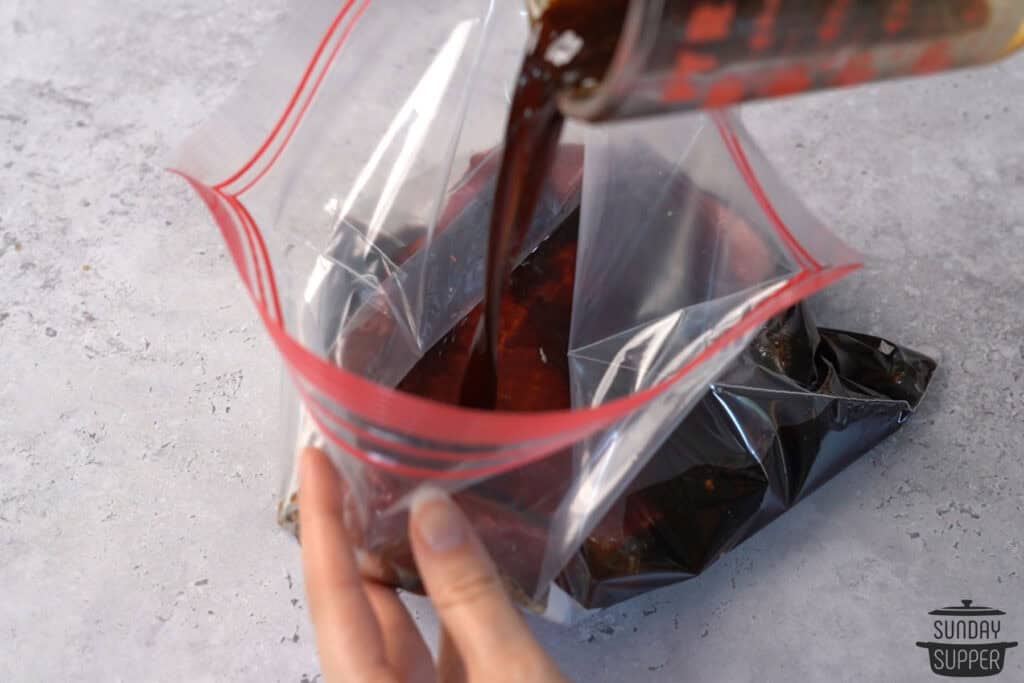 pouring london broil marinade into a bag