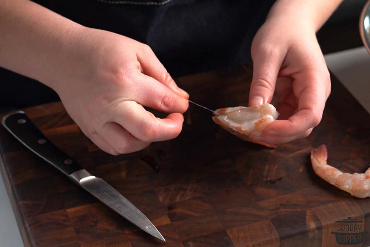 pulling out the vein of a shrimp with fingers