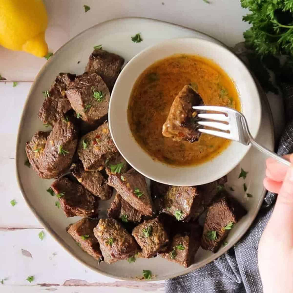 steak bites being dipped in cowboy butter