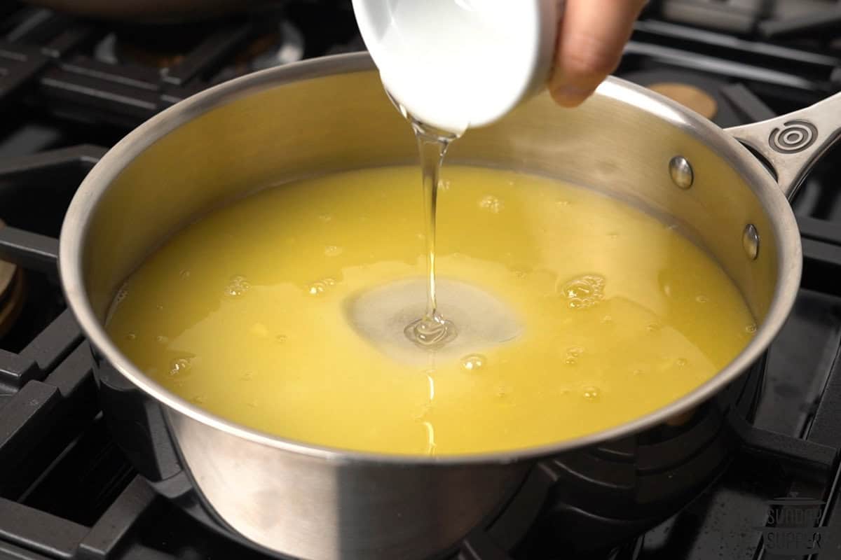 the candy sauce ingredients being added to a pan to combine