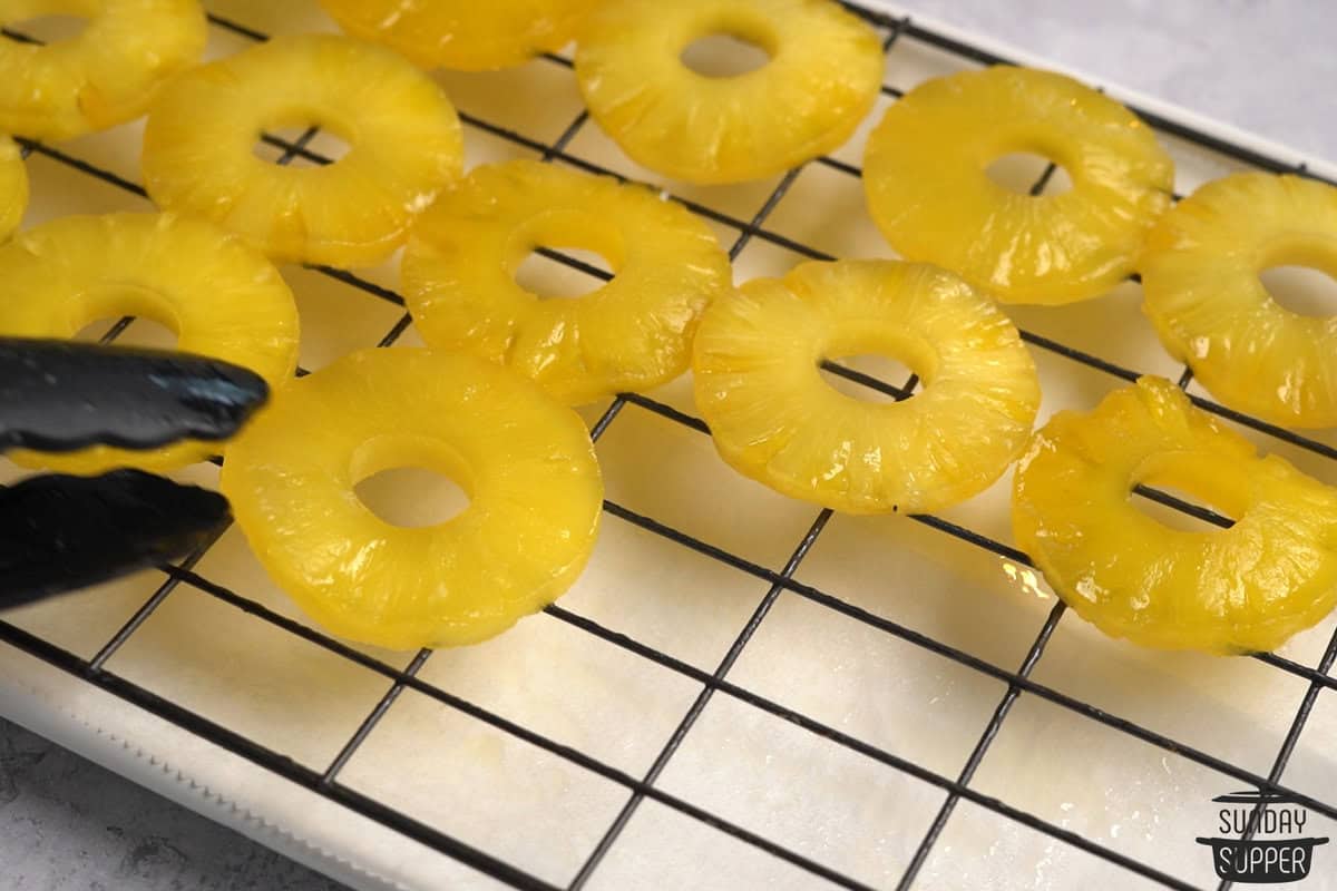 translucent pineapple rings being removed to a drying rack