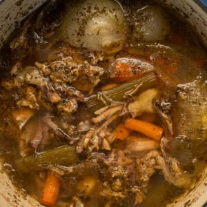 a top down view of a pot of bone broth before straining to show richness