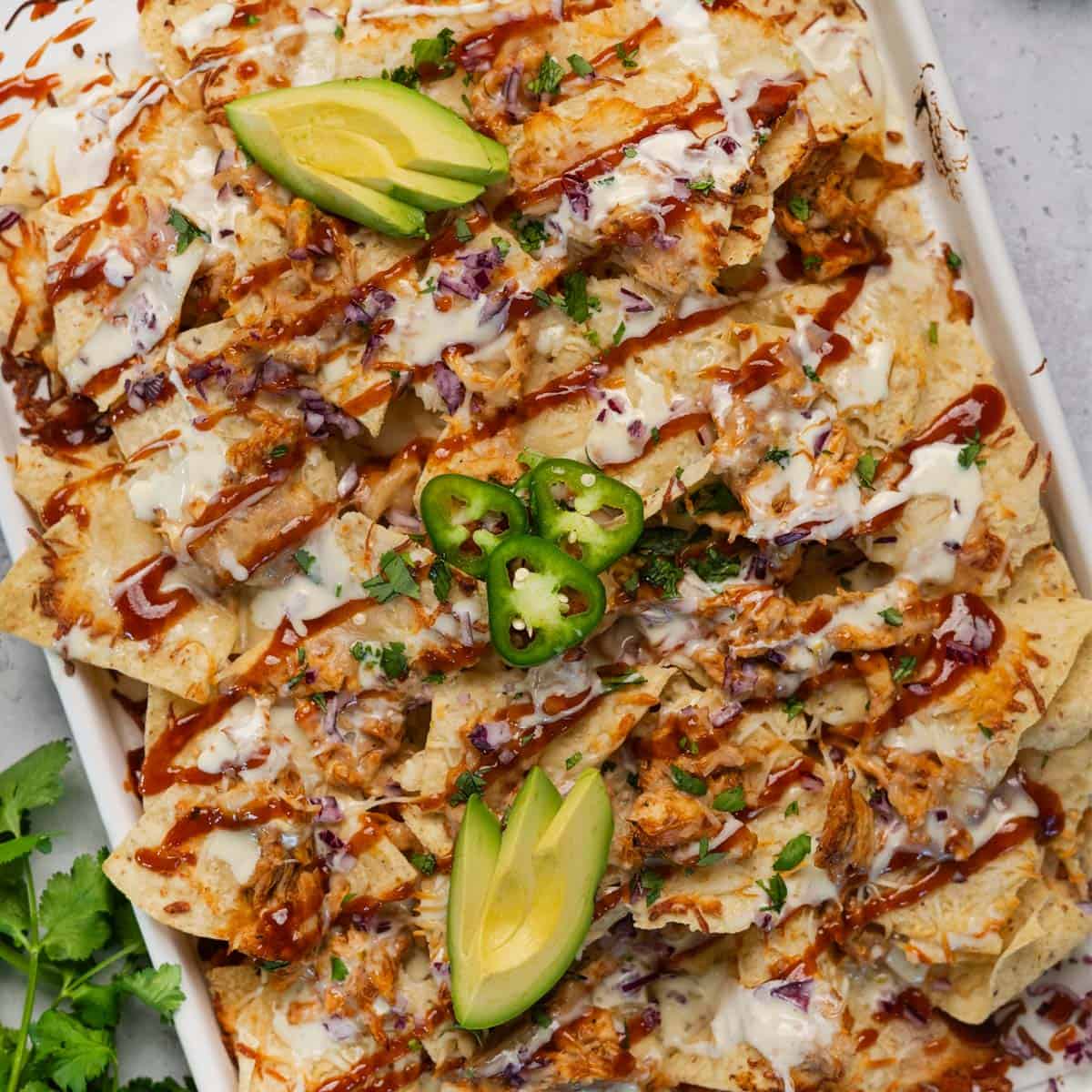 a closeup of a baking tray with loaded chicken nachos