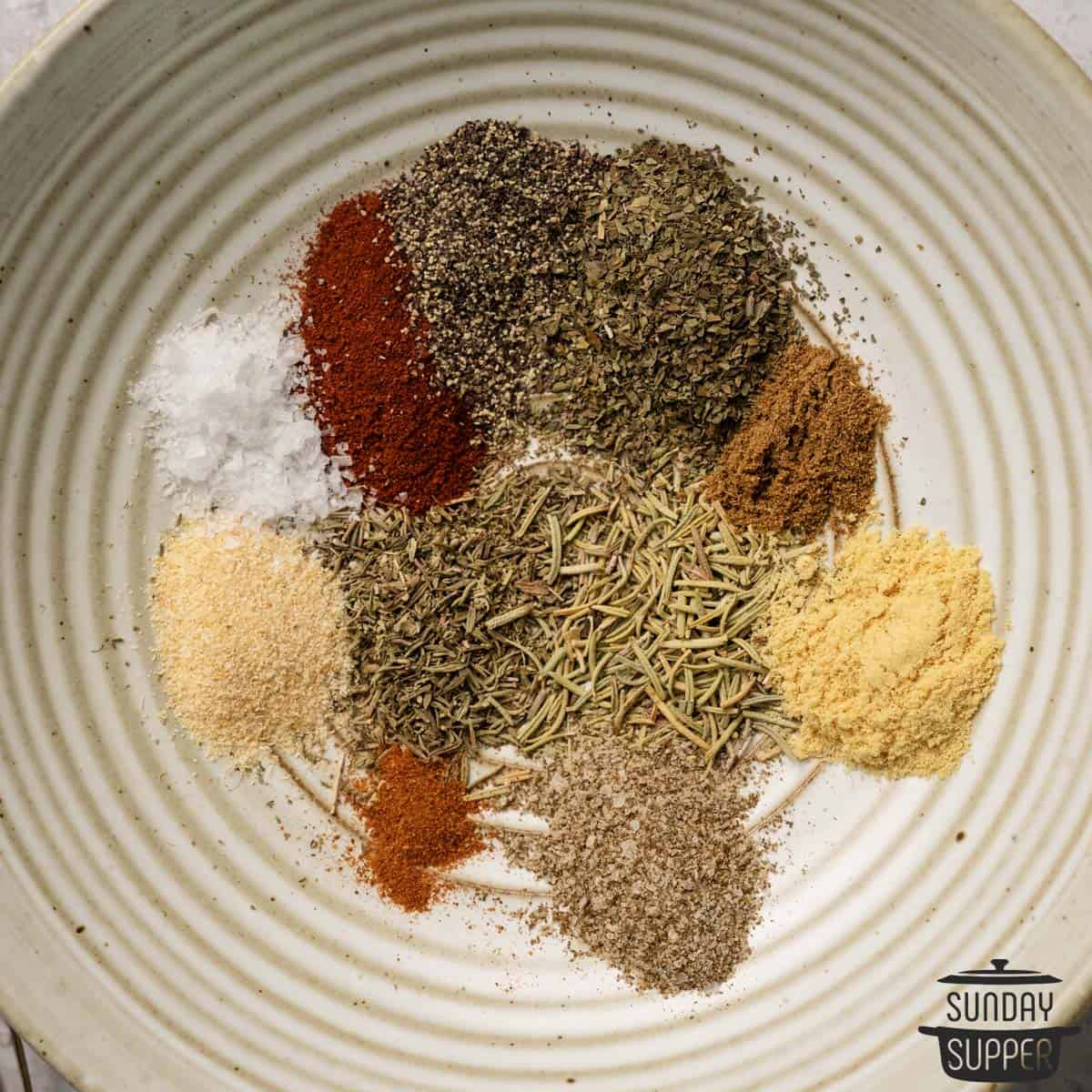 a bowl with separate piles of each chicken seasoning ingredient