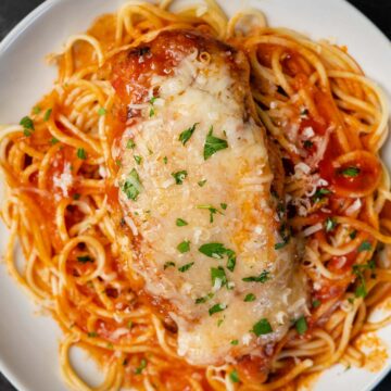 slow cooker chicken parm on top of spaghetti on a plate