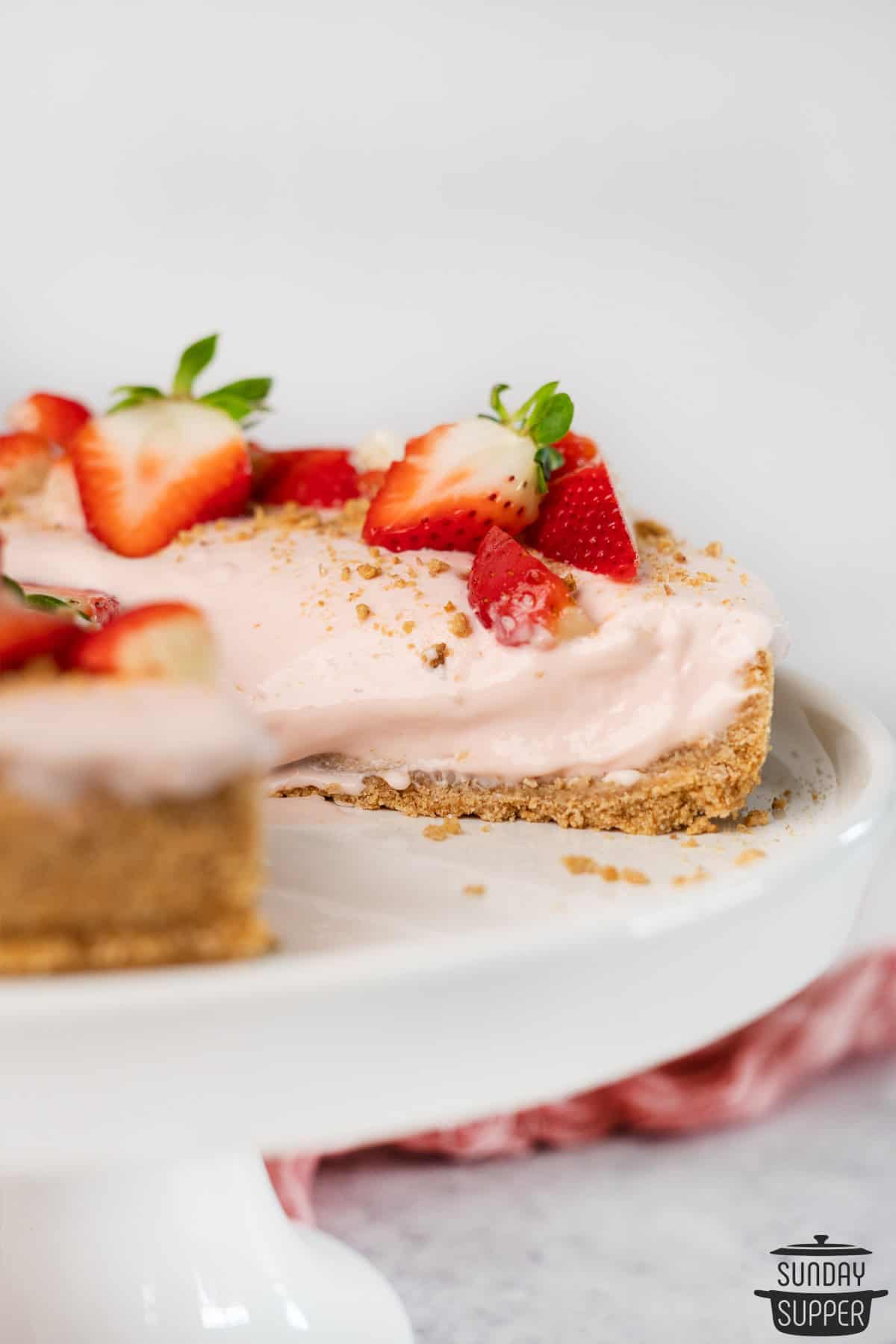 a sliced strawberry cheesecake showing off the creamy cheese filling