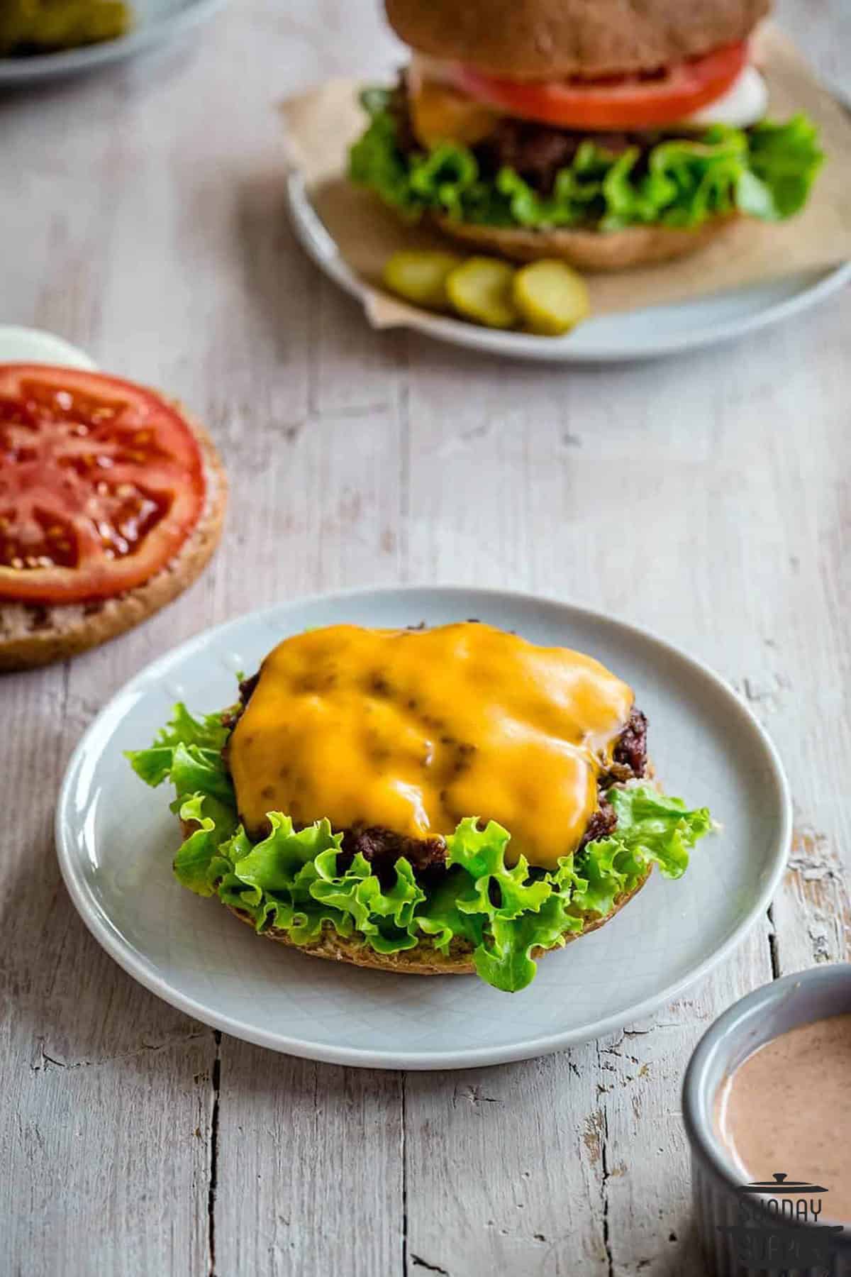 a smash burger on half a bun with melted cheese on top