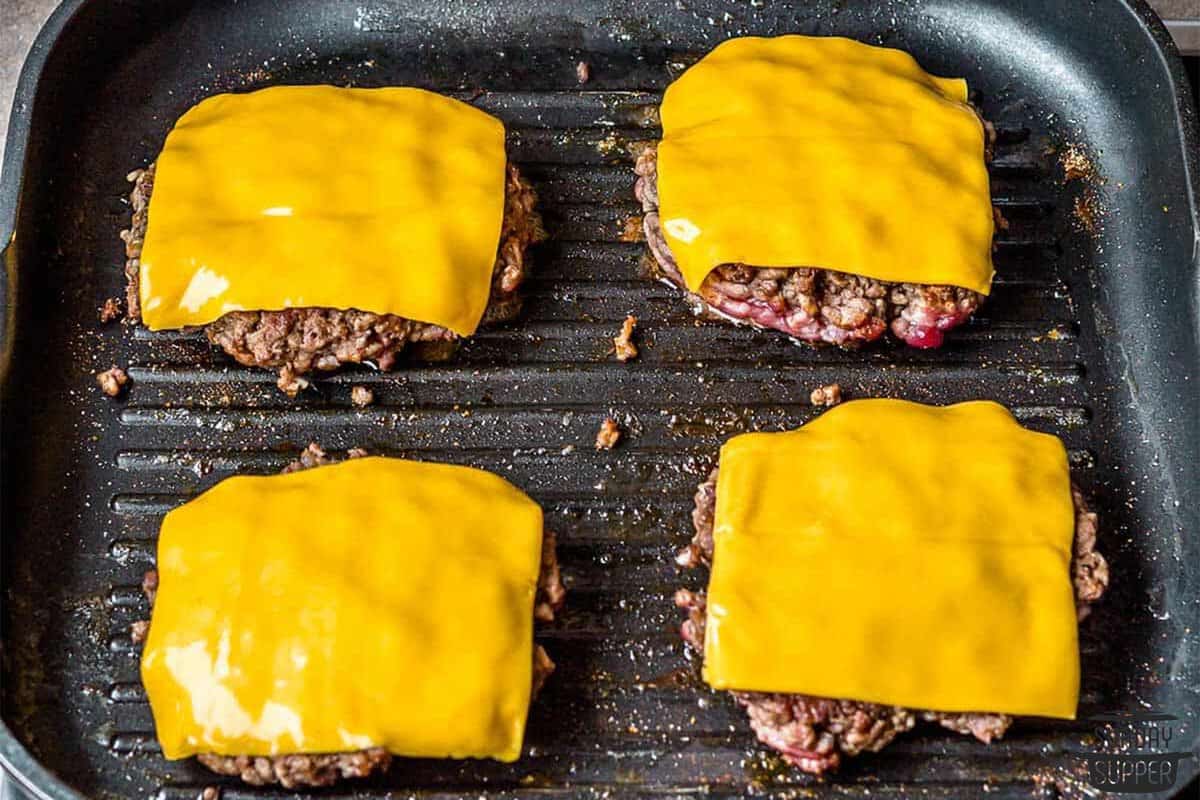 cheese added to the top of each burger patty to melt