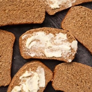 close of up slices of sprouted bread with butter on some slices