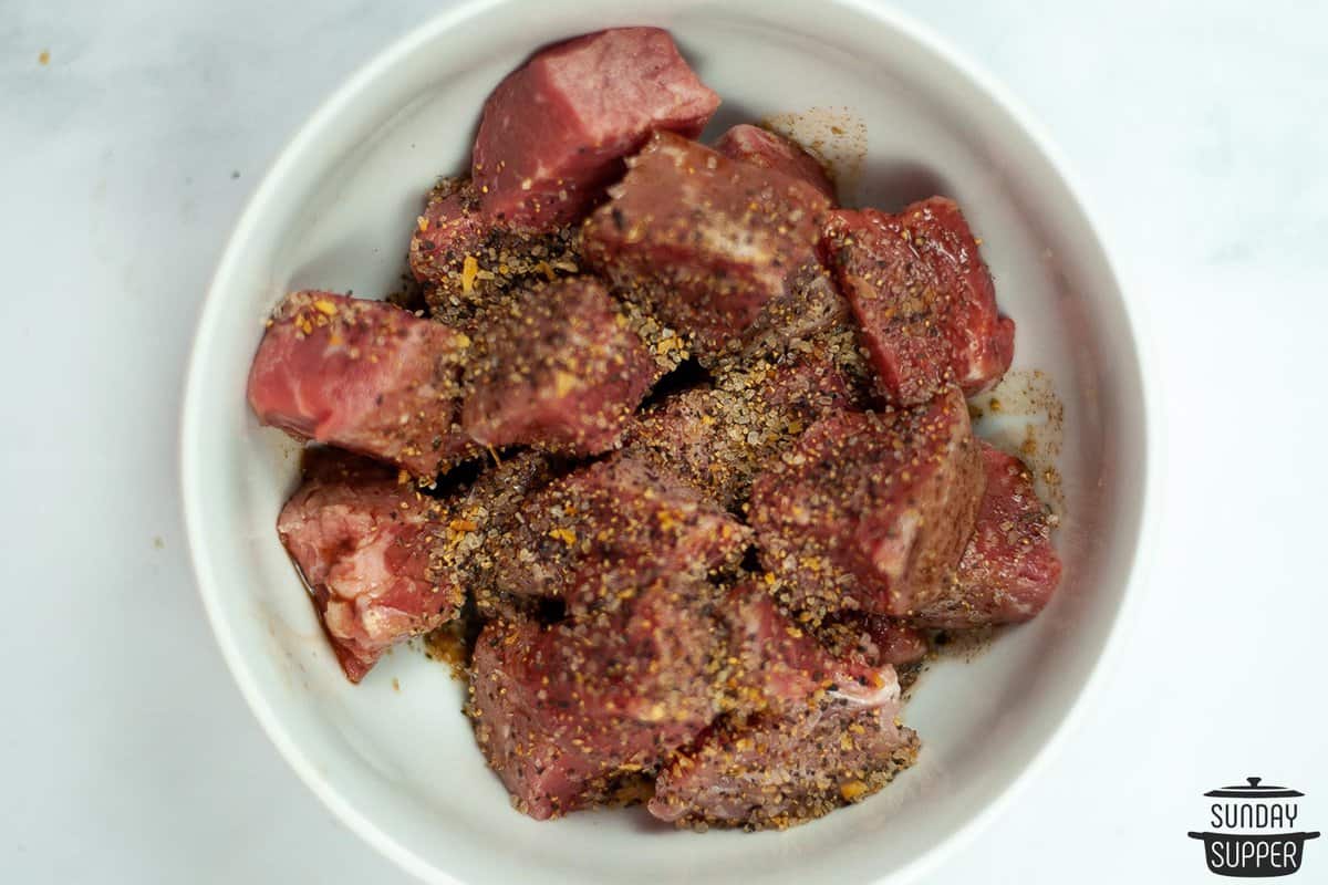 steak with worcestershire sauce and seasonings marinating in a small bowl