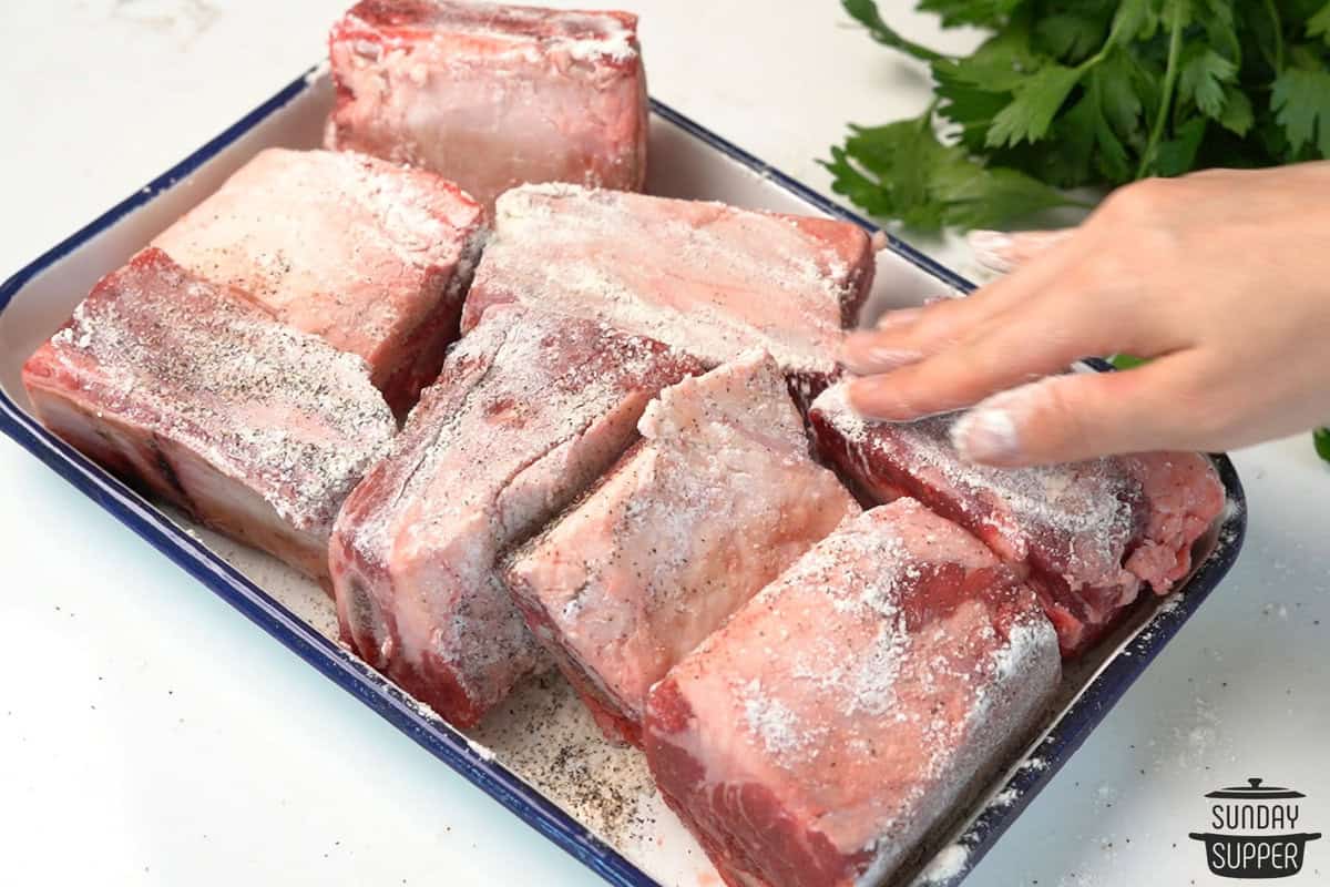 the seasonings being added to the short ribs