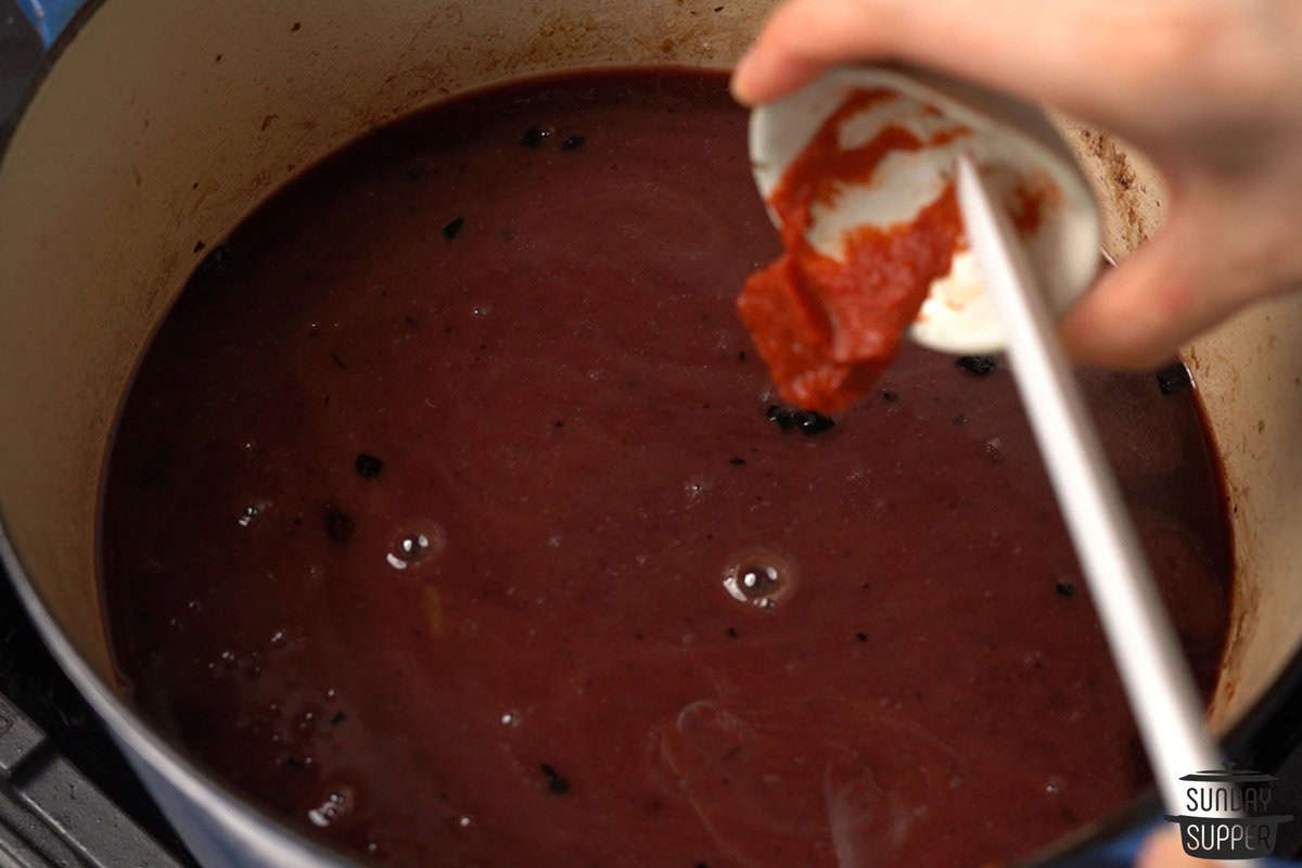 the broth being made with tomato paste and beef broth added