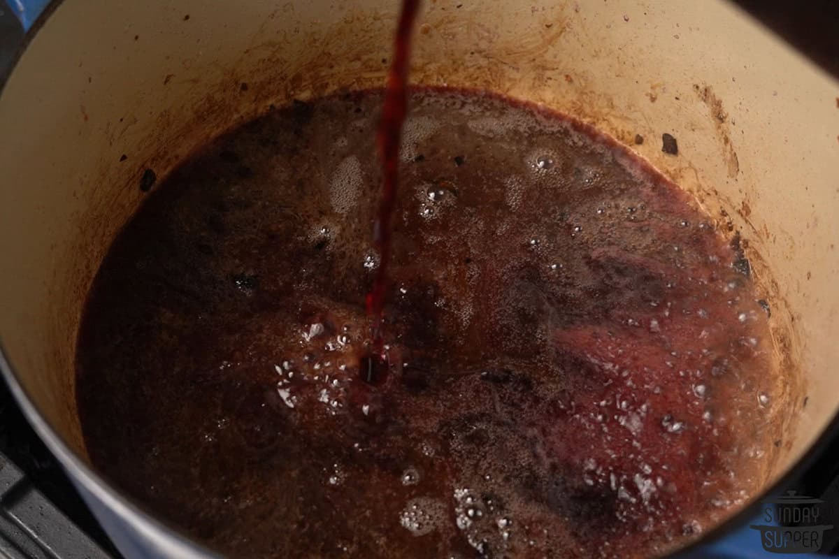 wine being added to the pot to deglaze the bottom