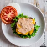 a burger on a plate with burger sauce on top