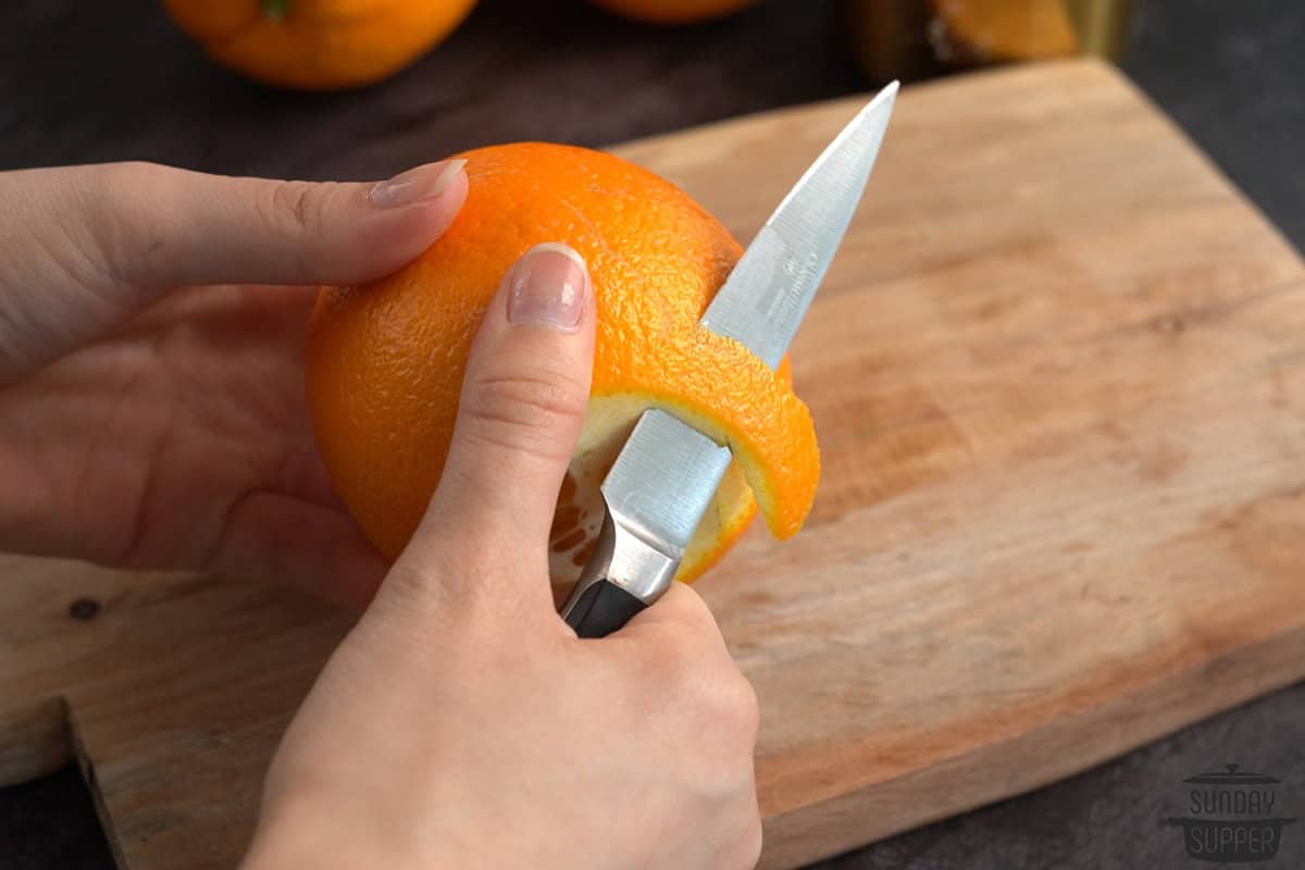 slicing the peels off the orange