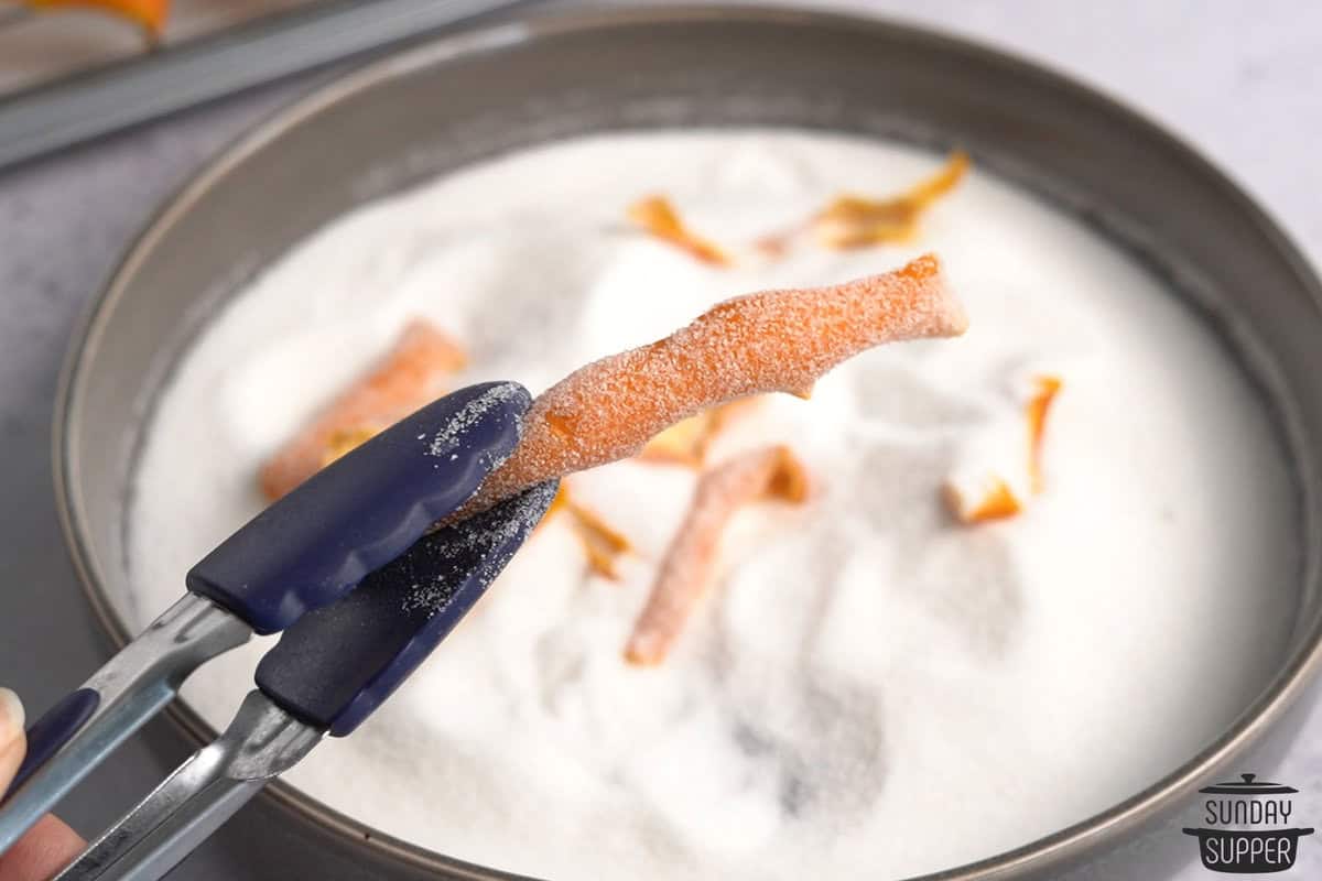 the orange peels being dredged in sugar