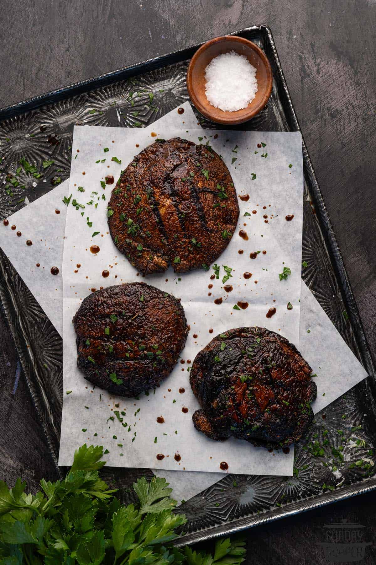 three grilled portobello mushroom caps on a serving tray