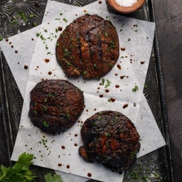 three grilled portobello mushrooms on a tray