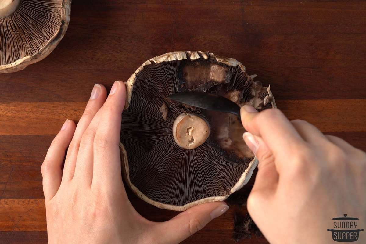 the mushroom caps being cleaned with a spoon