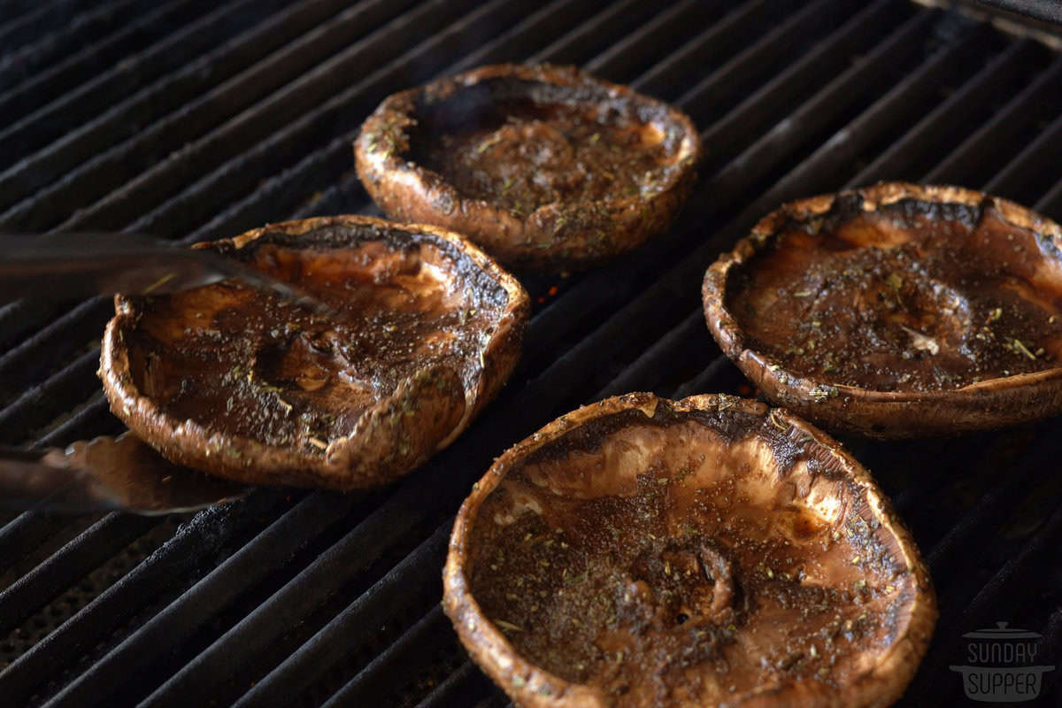 the mushrooms being placed on the grill