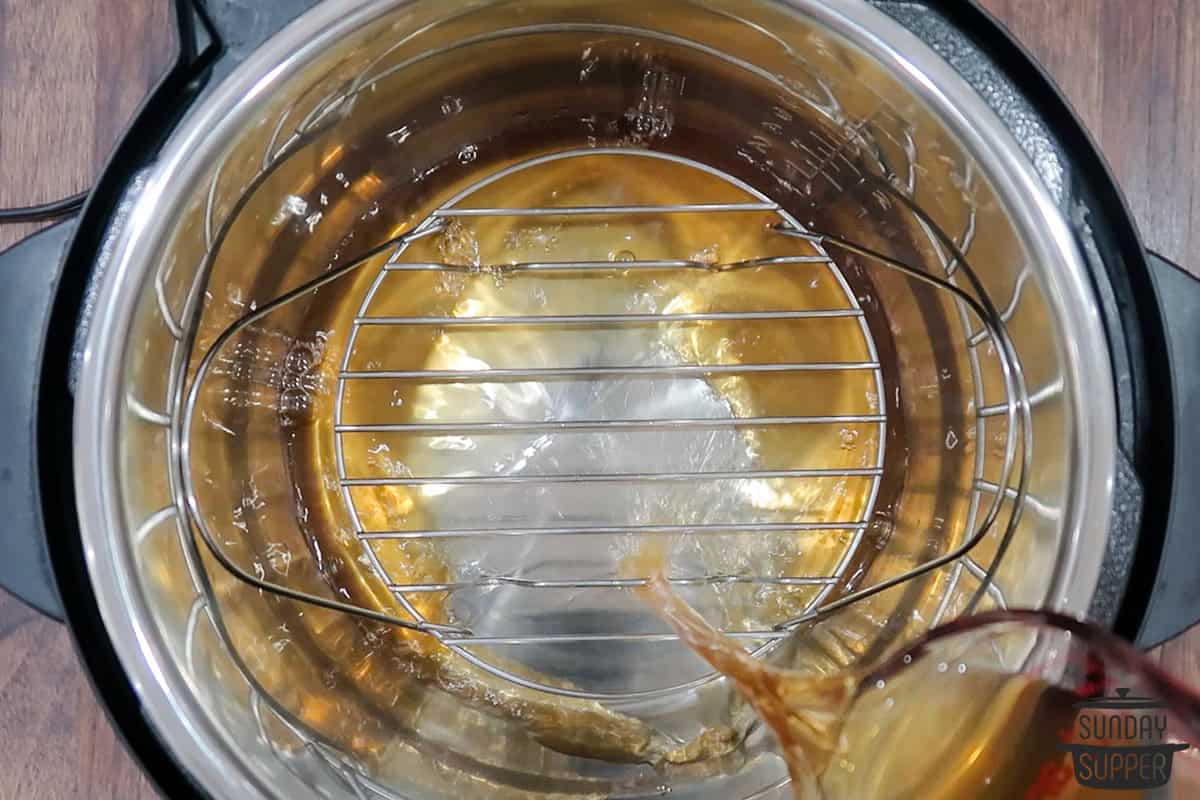 adding beef stock to the instant pot under the rack