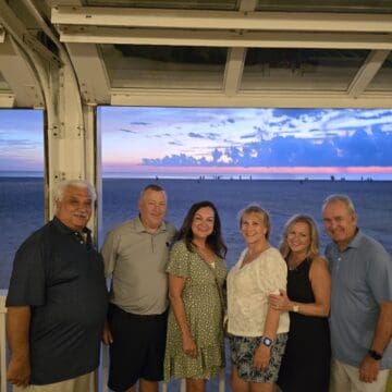 isabel and her family and friends in front of a beautiful sunset