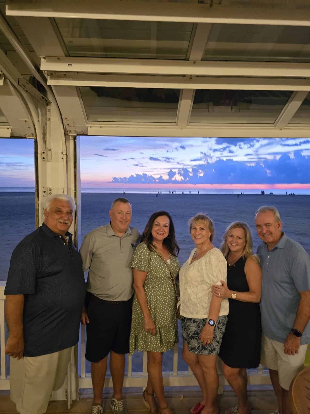 isabel and her family and friends in front of a beautiful sunset