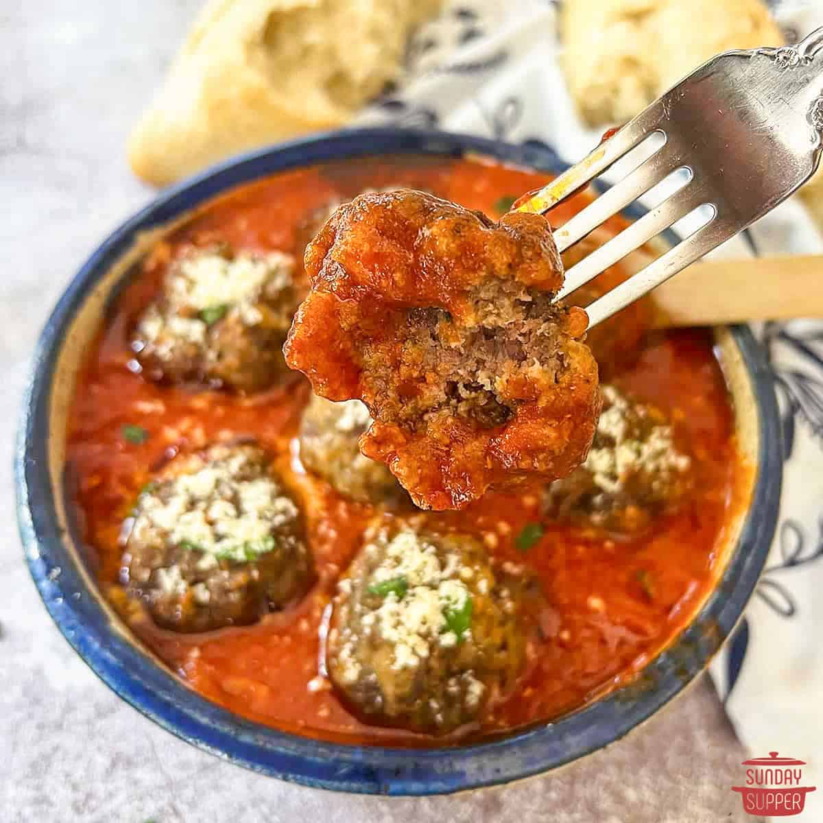 italian meatballs in tomato sauce with a fork