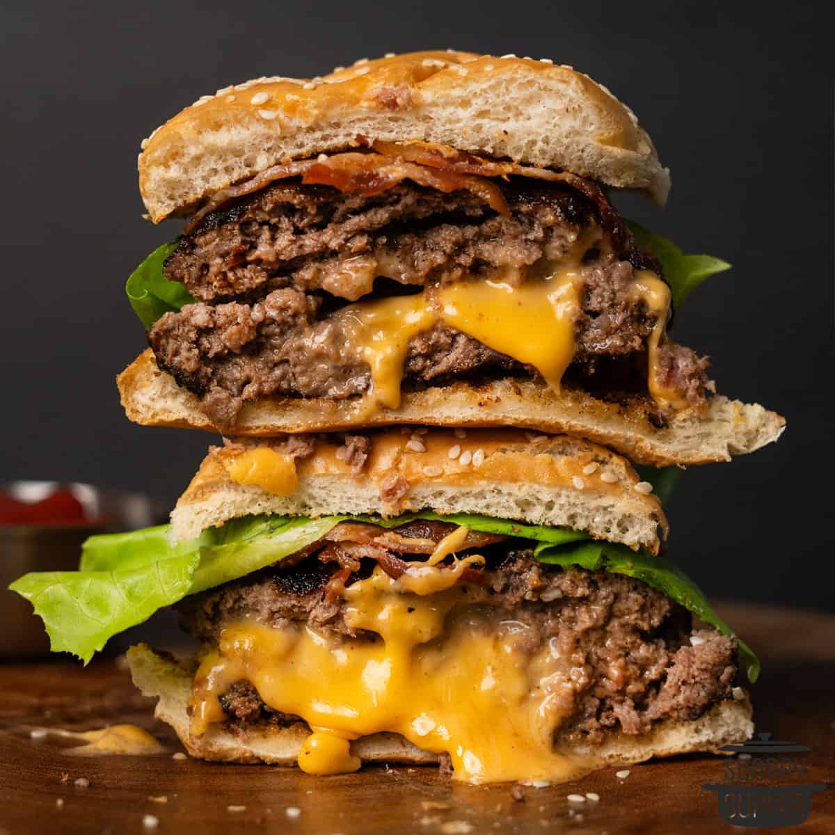 two halves of a cut open juicy lucy burger stacked on top of each other