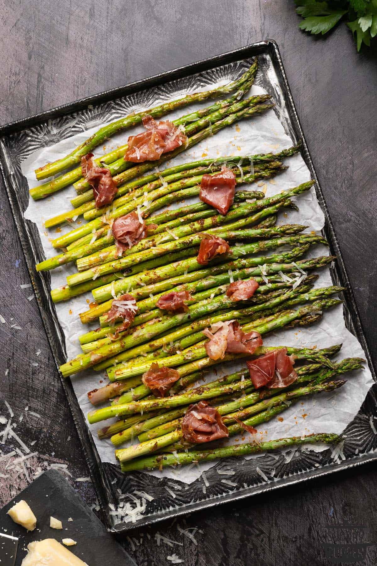 a serving platter of roasted asparagus with prosciutto and parmesan